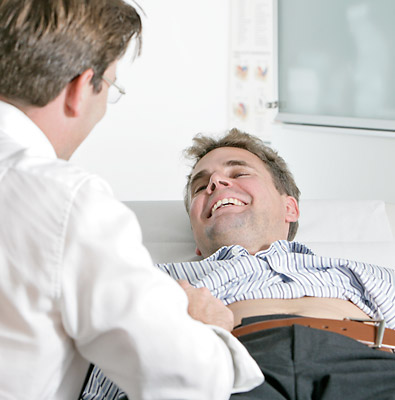 lächelnder Patient am Behandlungsstuhl mit dem Urologen Dr. Patrick Bössner